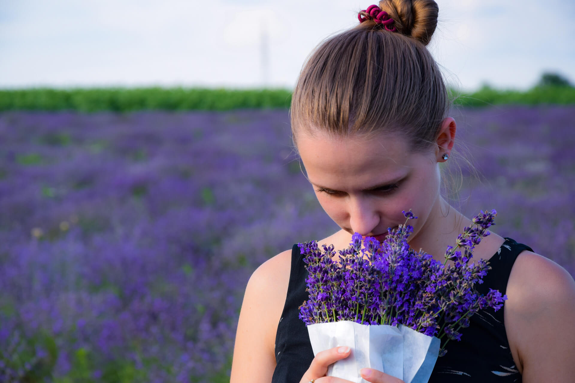 A person holding a flower

            Description automatically generated